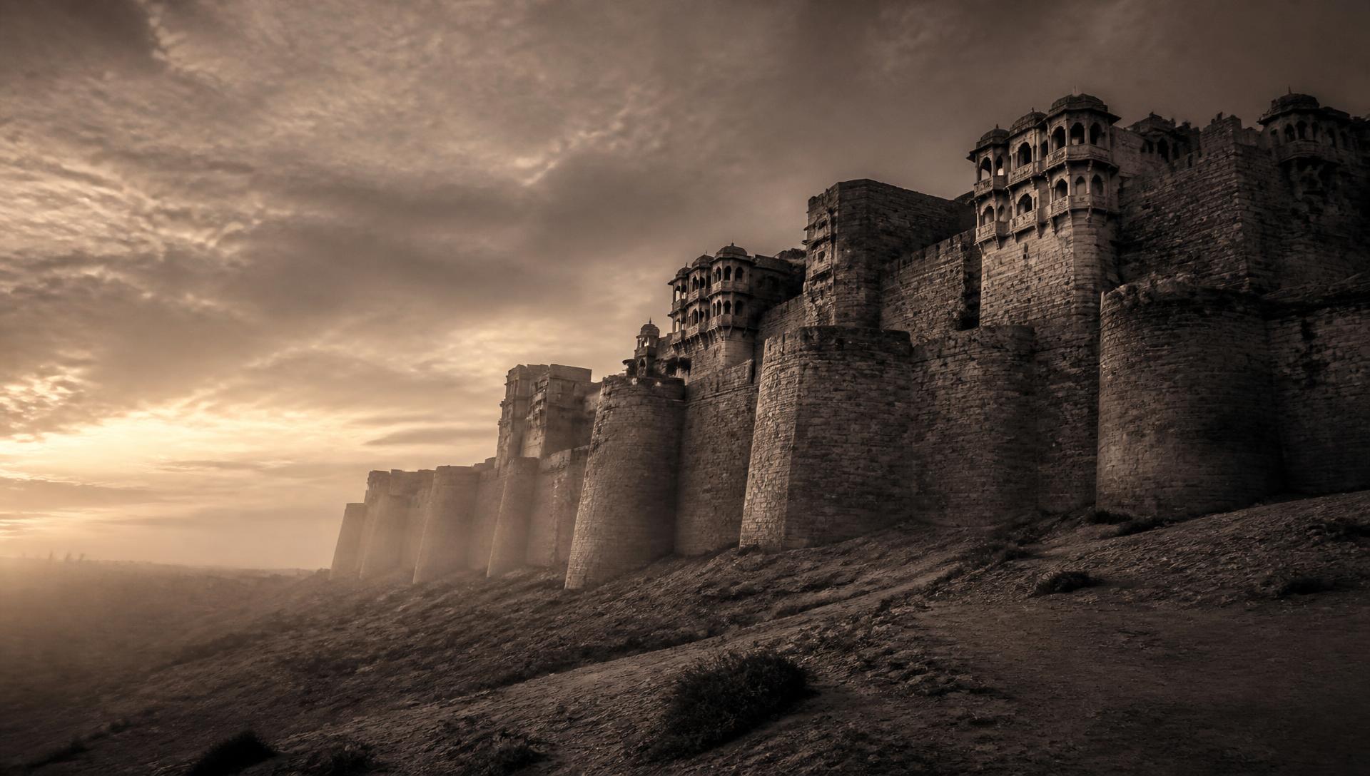 Ancient Rajasthani fort wall rising out of the desert at dusk